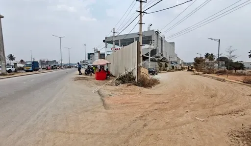 A view looking down the unpaved approach road situated right beside the bustling highway near Sobha One Residences