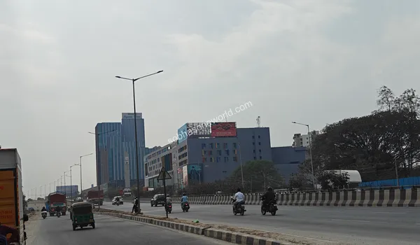 Wide view of the multilane highway leading towards the Sobha One World project showcasing nearby commercial infrastructure