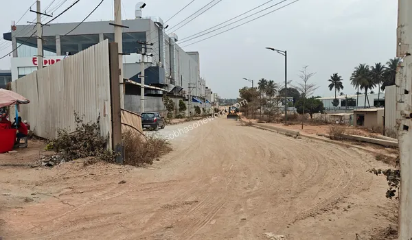 A view of the inner access road progressing deep into the Sobha One World site, flanked by surrounding greenery.