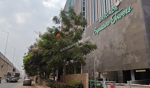 Impressive corporate facade with bright red signage representing the thriving business ecosystem neighboring Sobha One World