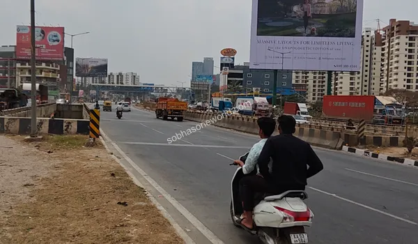 Broad urban roadway directing traffic towards KR Puram located exactly at the Sobha One World entrance area